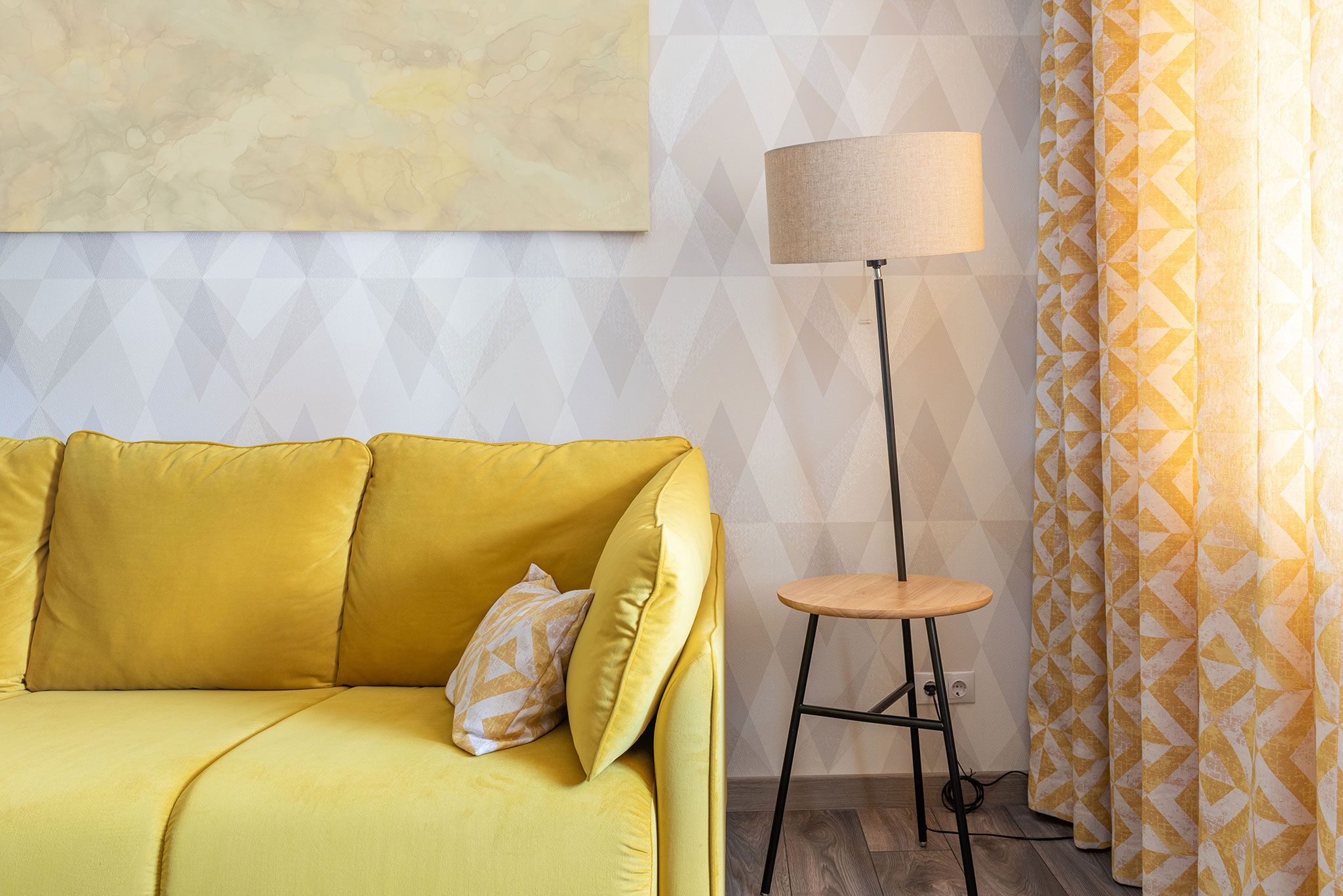 żółta sofa na tle jasnej geometrycznej ściany