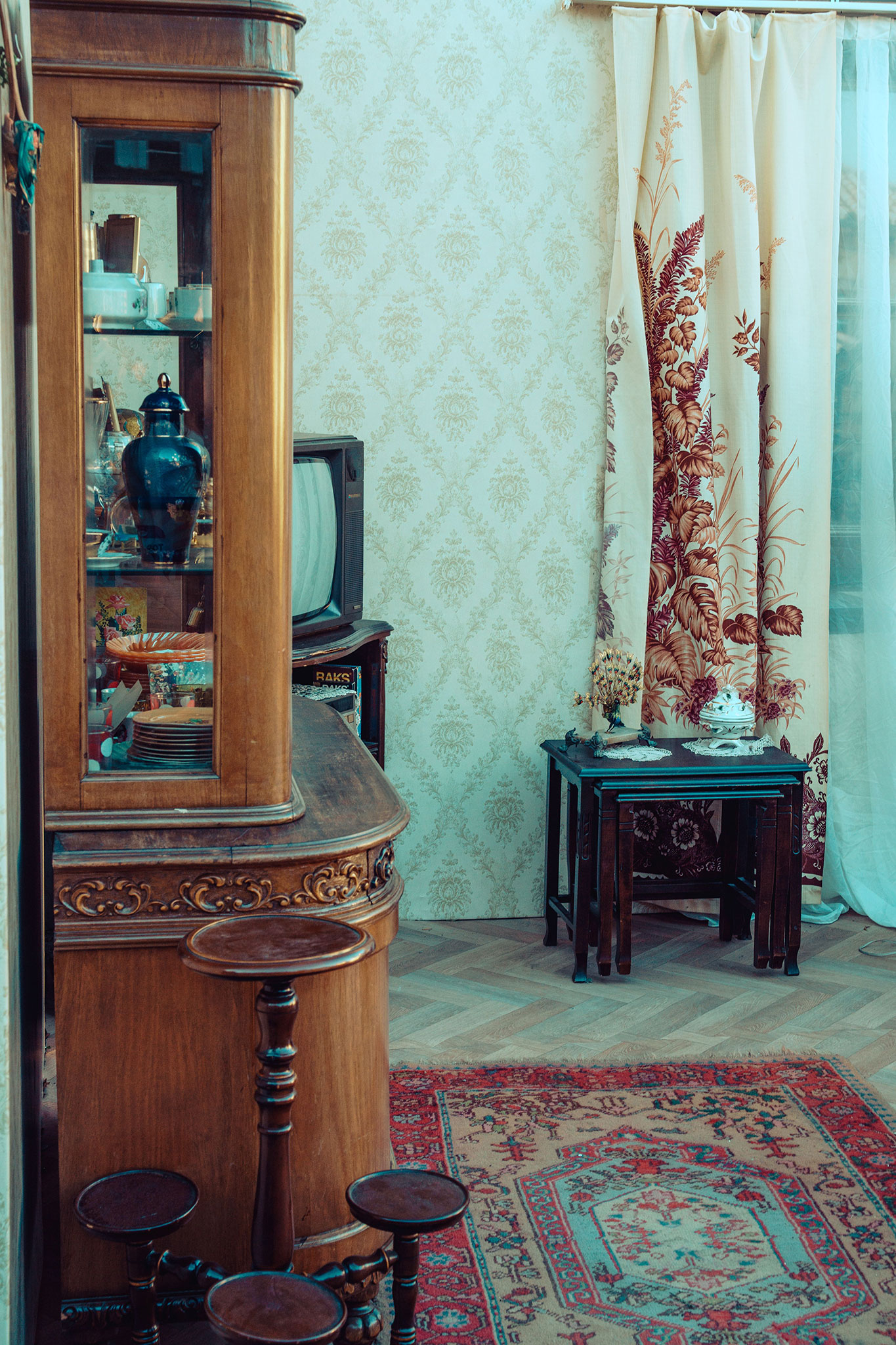 drewniana witryna i wzorzysty dywan w salonie vintage