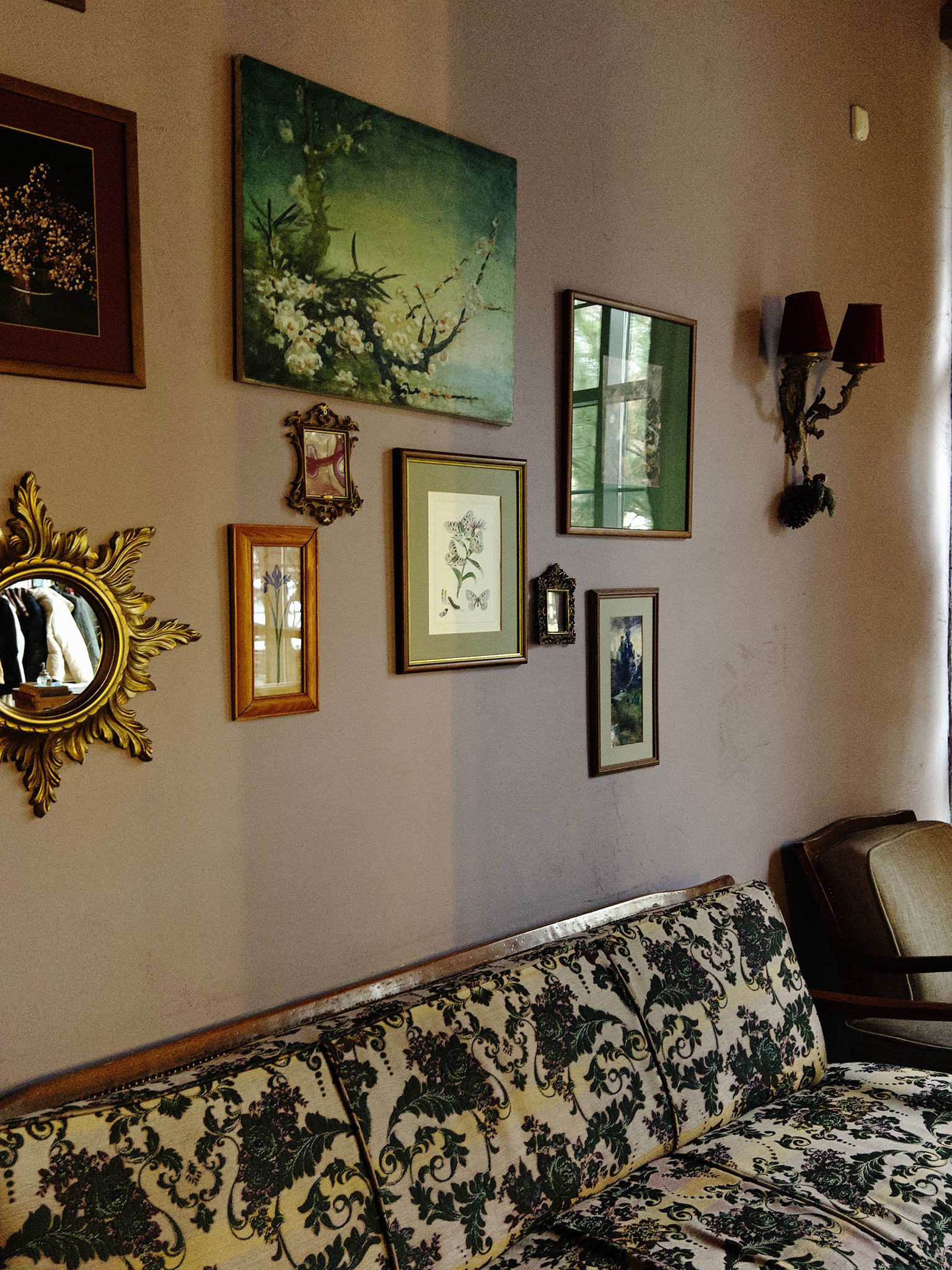 salon vintage z galerią obrazów i wzorzystą sofą