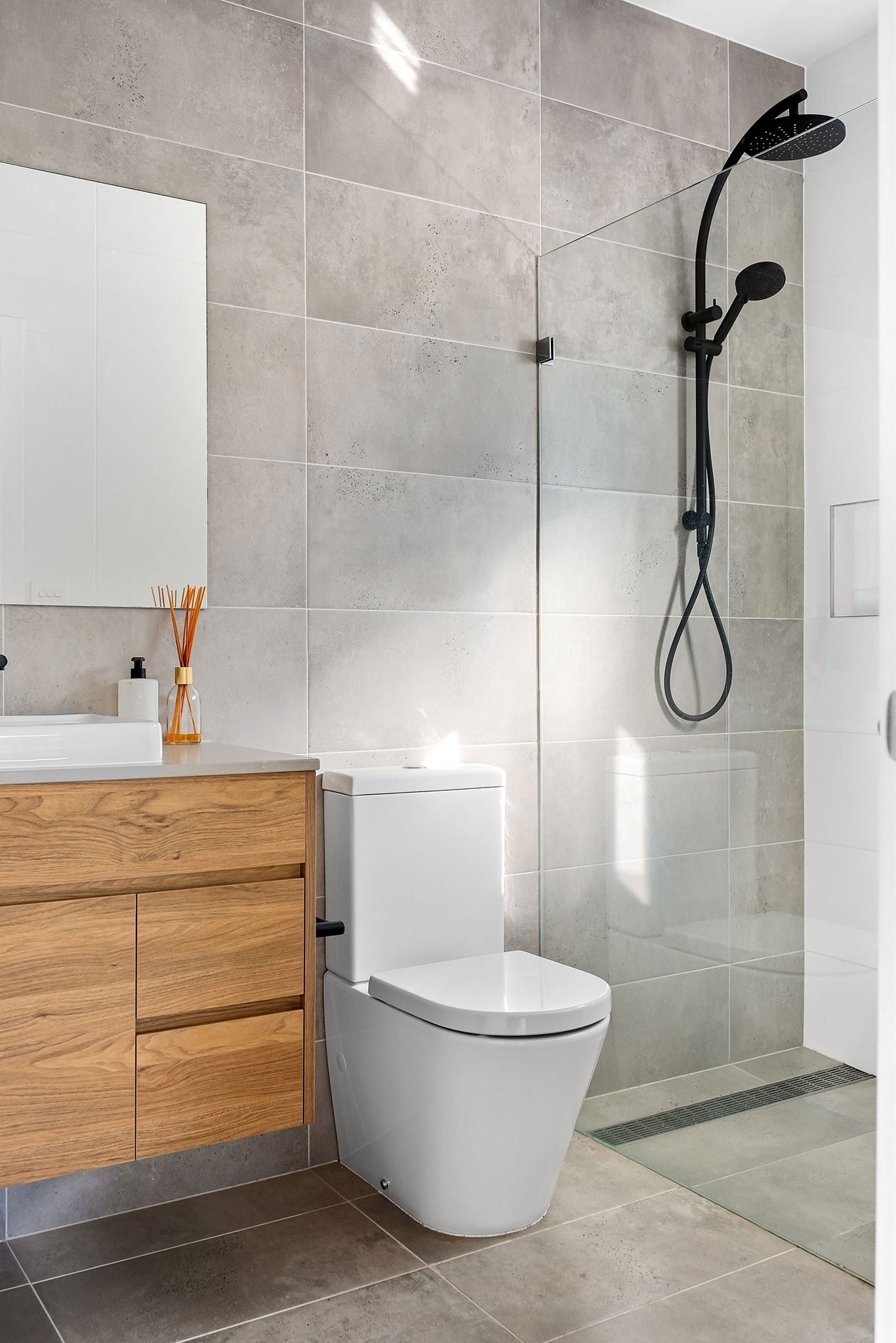 mała łazienka z prysznicem walk-in, WC i drewnianą szafką