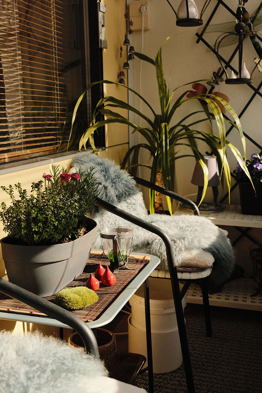 przytulny balkon wieczorem z lampionami, roślinami i miękkim siedziskiem