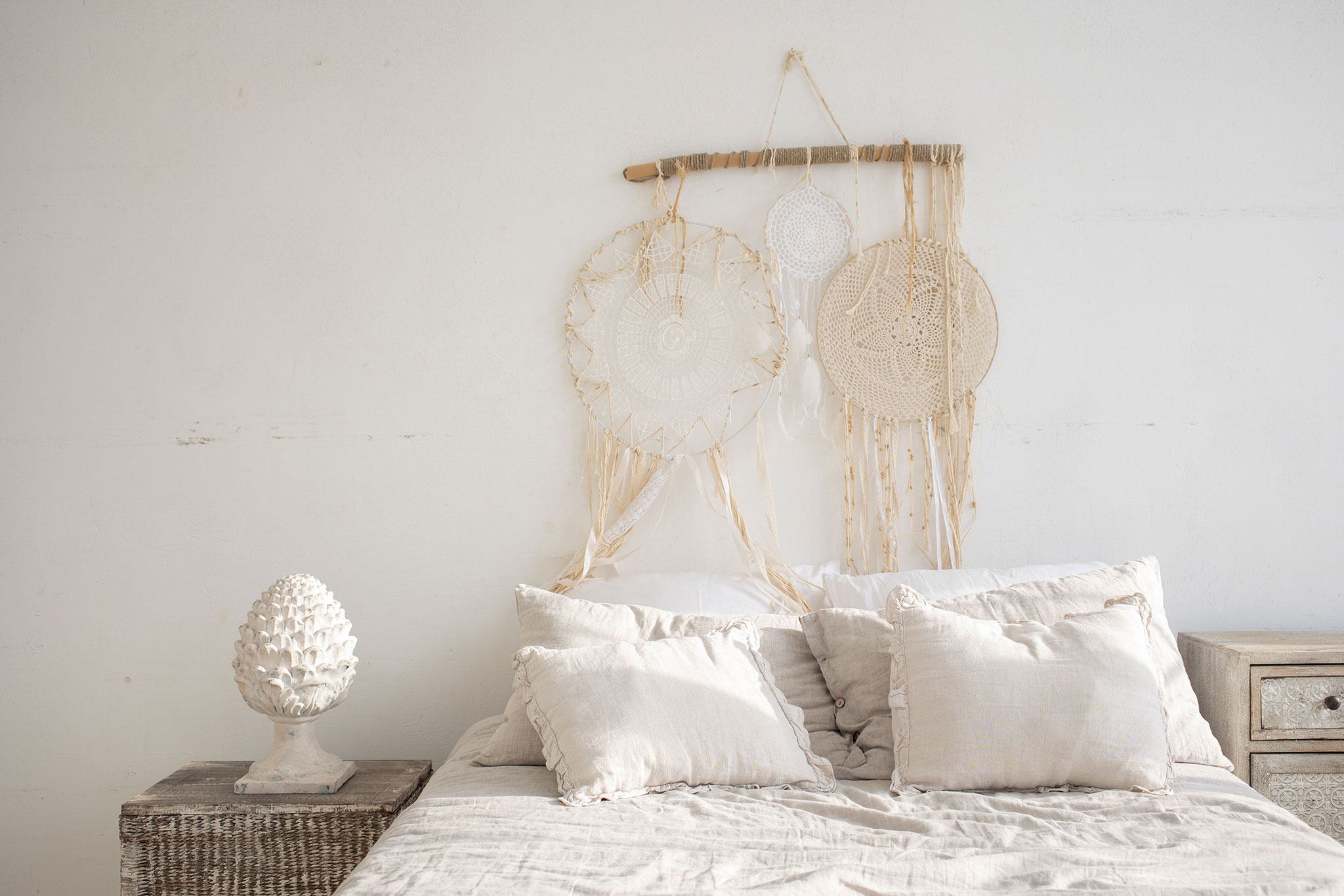sypialnia scandi boho z jasnymi tekstyliami i dekoracją nad łóżkiem