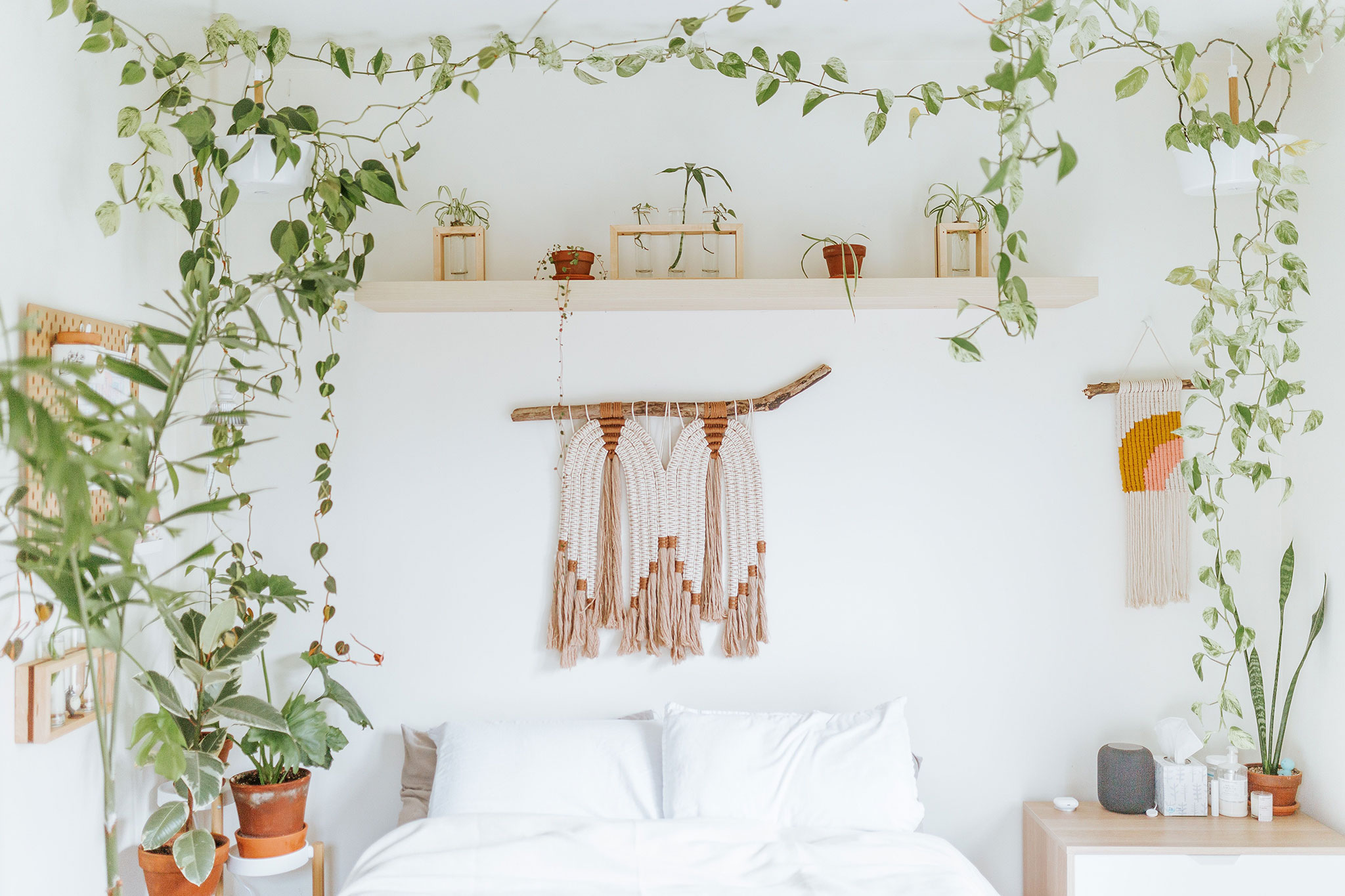 jasna sypialnia scandi boho z roślinami i makramą nad łóżkiem