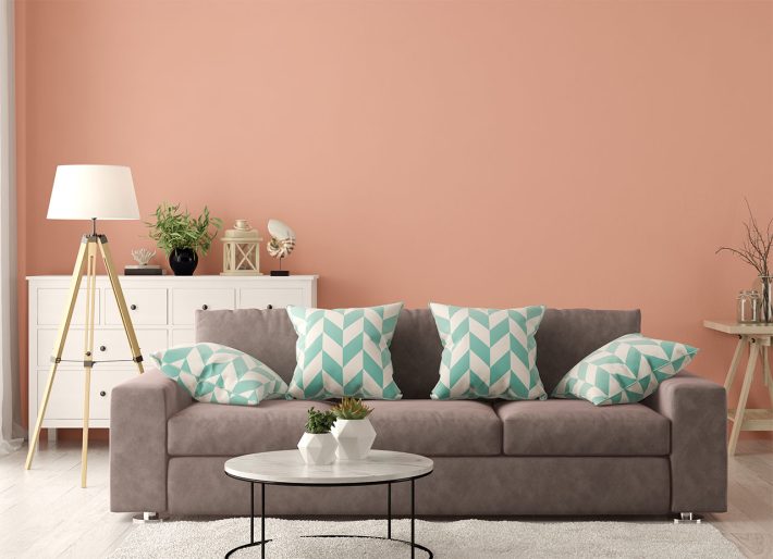 modne kolory ścian w salonie – terakotowa ściana i nowoczesna aranżacja z sofą