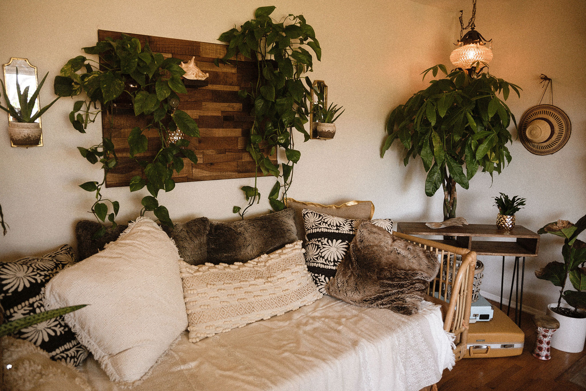 Salon boho z roślinami, poduszkami i naturalnymi dodatkami